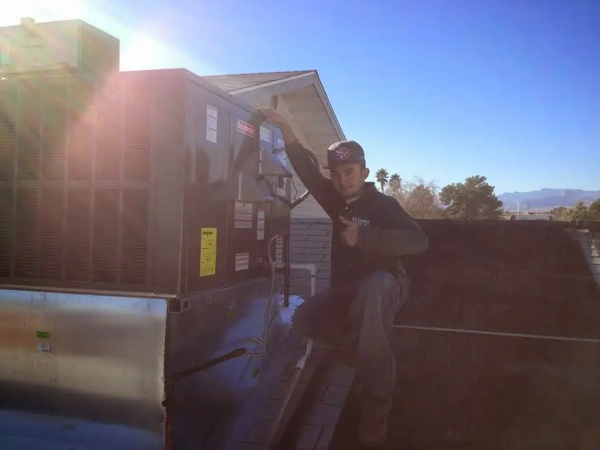 HVAC technician performing HVAC Inspection on a rooftop unit in Rochelle